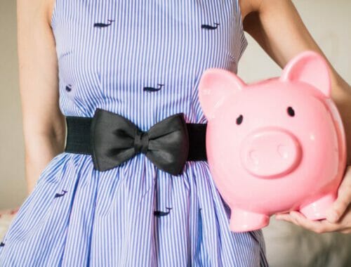 lady in stripped dress with piggy bank