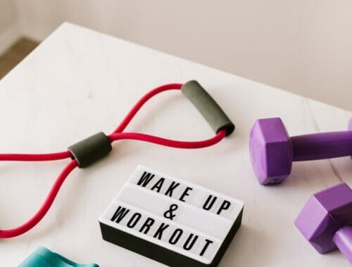wake up and workout slogan on light box among sports equipment